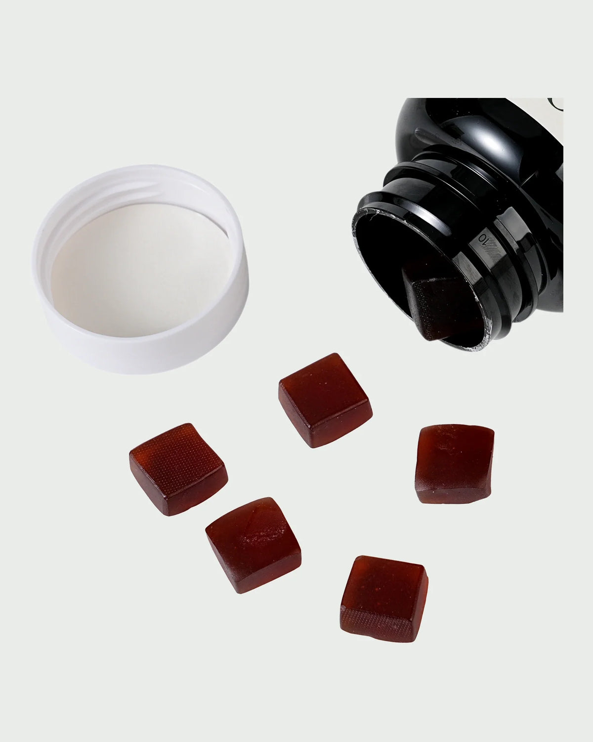 The Veya bottle on its side with the white cap off, gummies resting on the surface beside it.