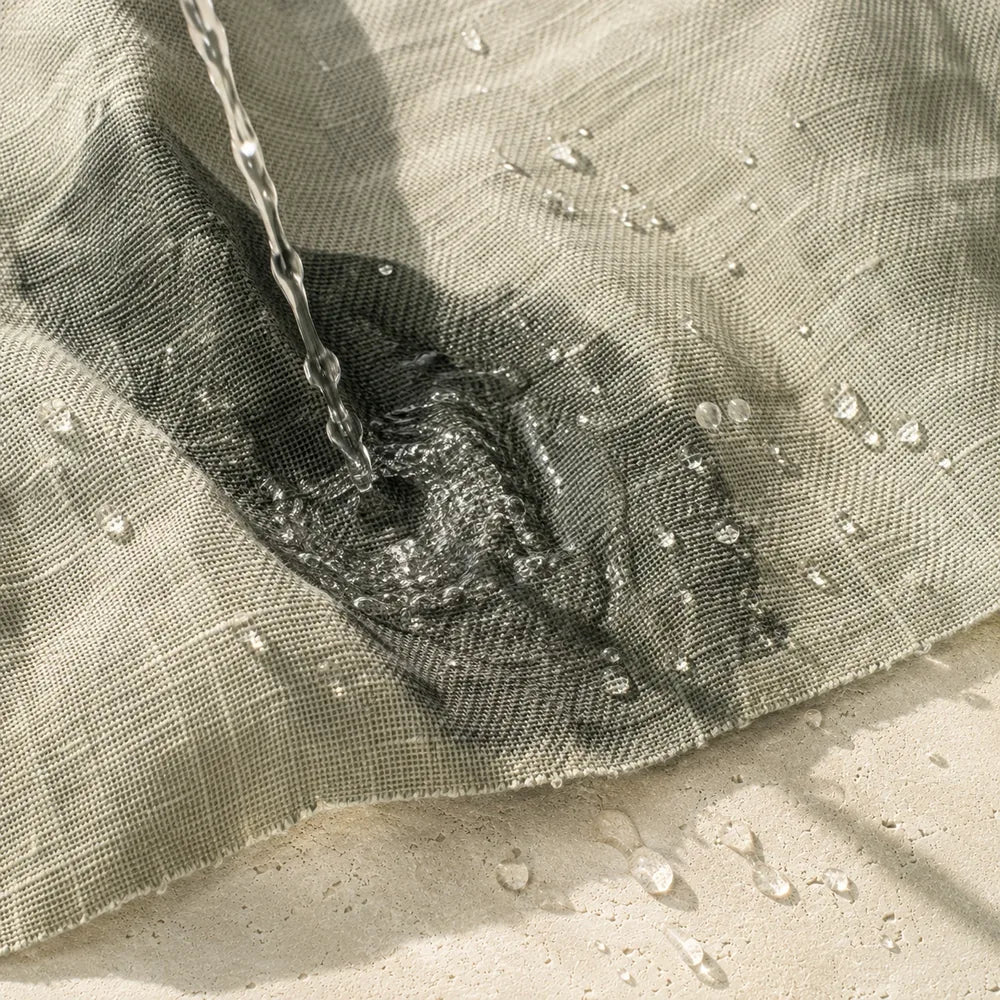 A thin stream of water falling onto folded linen